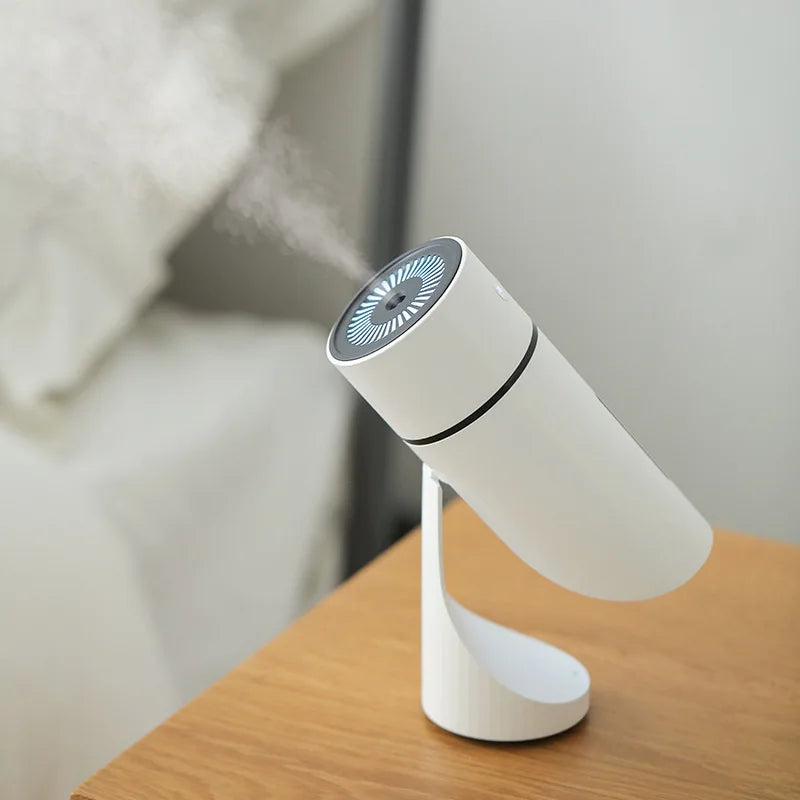 Humidificateur AirPur Nomade™ sur une table de chevet, diffusant une brume et une lumière chaude, créant une ambiance apaisante pour la chambre.