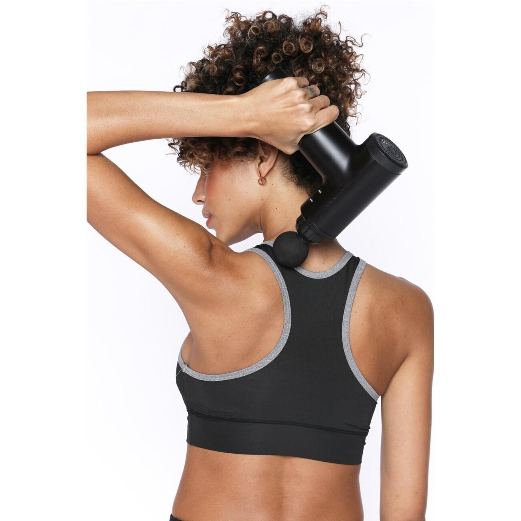 Femme utilisant le pistolet de massage PulseGun Mini™ sur sa nuque et ses trapèzes pour soulager les tensions cervicales liées au travail de bureau.