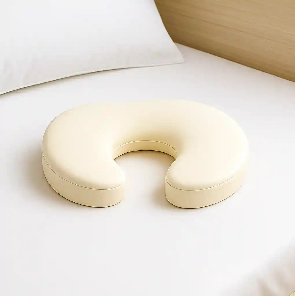 coussin décharge sacrum au lit posé sur une surface plane, forme ergonomique visible