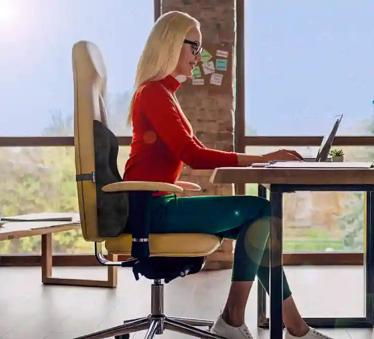 Femme utilisant un coussin maintien du dos ergonomique sur chaise de bureau
