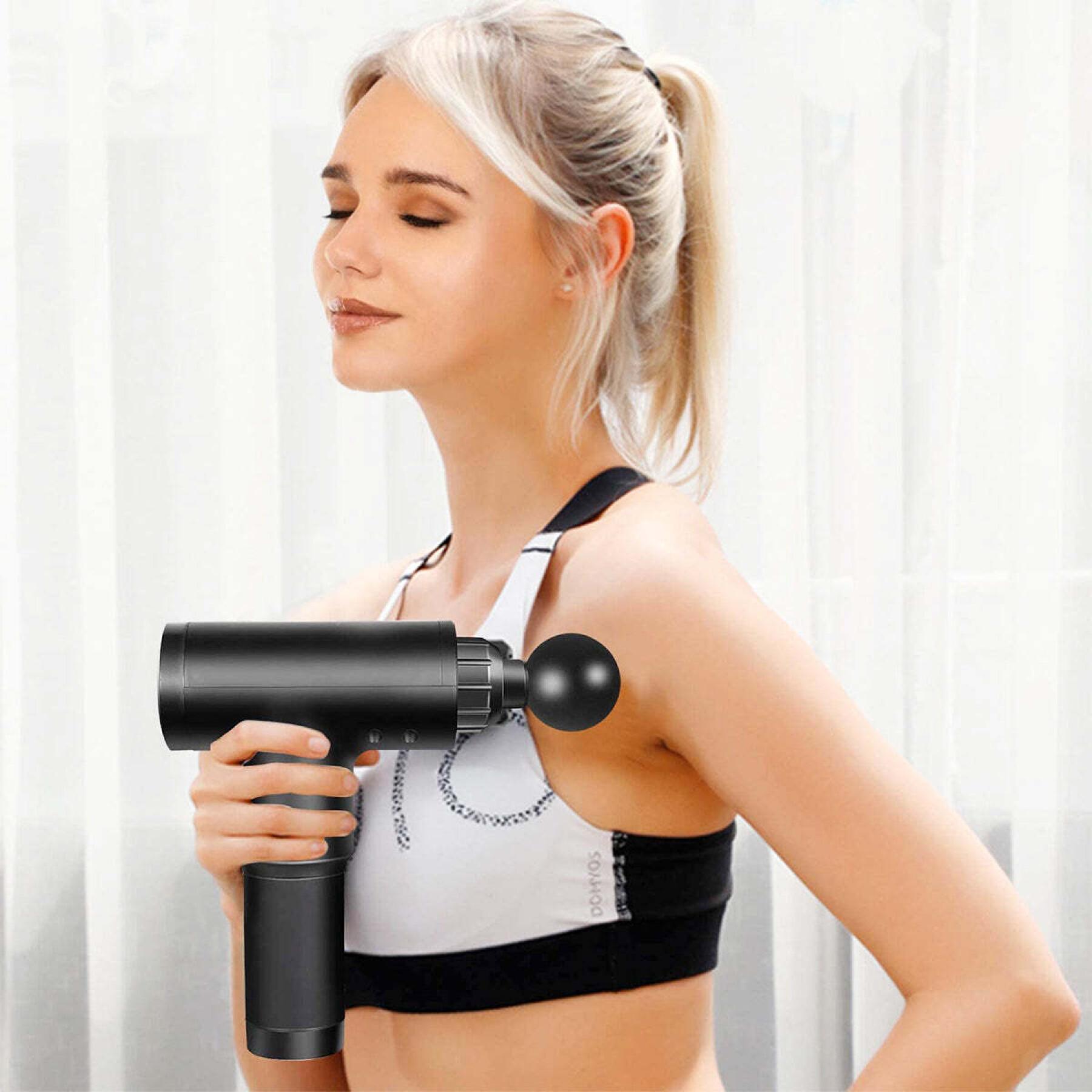Femme utilisant le pistolet de massage PulseGun Mini™ sur son épaule pour un massage relaxant et un moment de bien-être personnel.